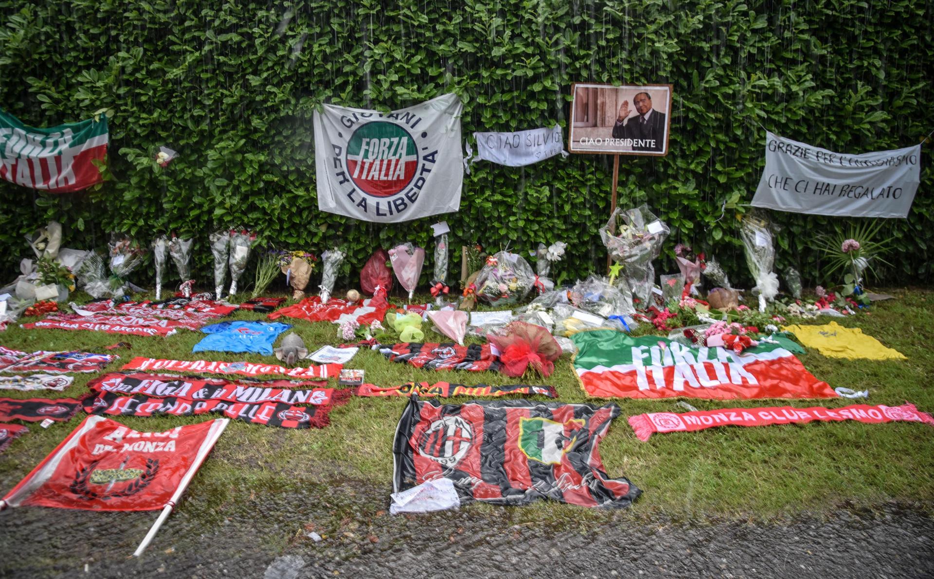 Flores y objetos de recuerdo que los seguidores de Berlusconi han depositado en la entrada de la Villa Martino de Arcore, a las afueras de Milán. EFE/EPA/MATTEO CORNER