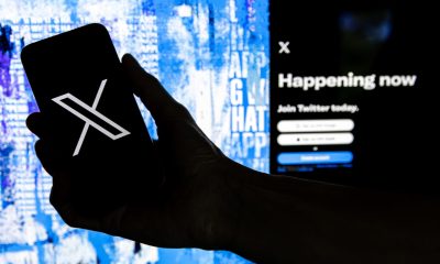 Fotografía que muestra un usuario mientras sostiene un teléfono móvil que muestra el logotipo 'X' frente a la página principal de Twitter, el 28 de julio de 2023 en Los Ángeles, California (EE.UU.). EFE/EPA/ETIENNE LAURENT