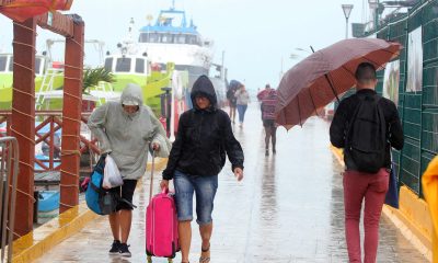 Fotografía de archivo de turistas caminando bajo la lluvia en las playas de Cancún en el estado de Quintana Roo (México). EFE/Alonso Cupul