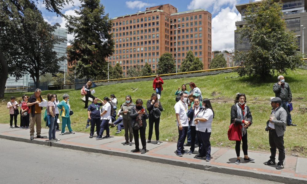 Personas se reúnen afuera de un edificio luego de ser evacuadas debido a un sismo de 6.1 hoy, en Bogotá (Colombia). EFE/Mauricio Dueñas Castañeda