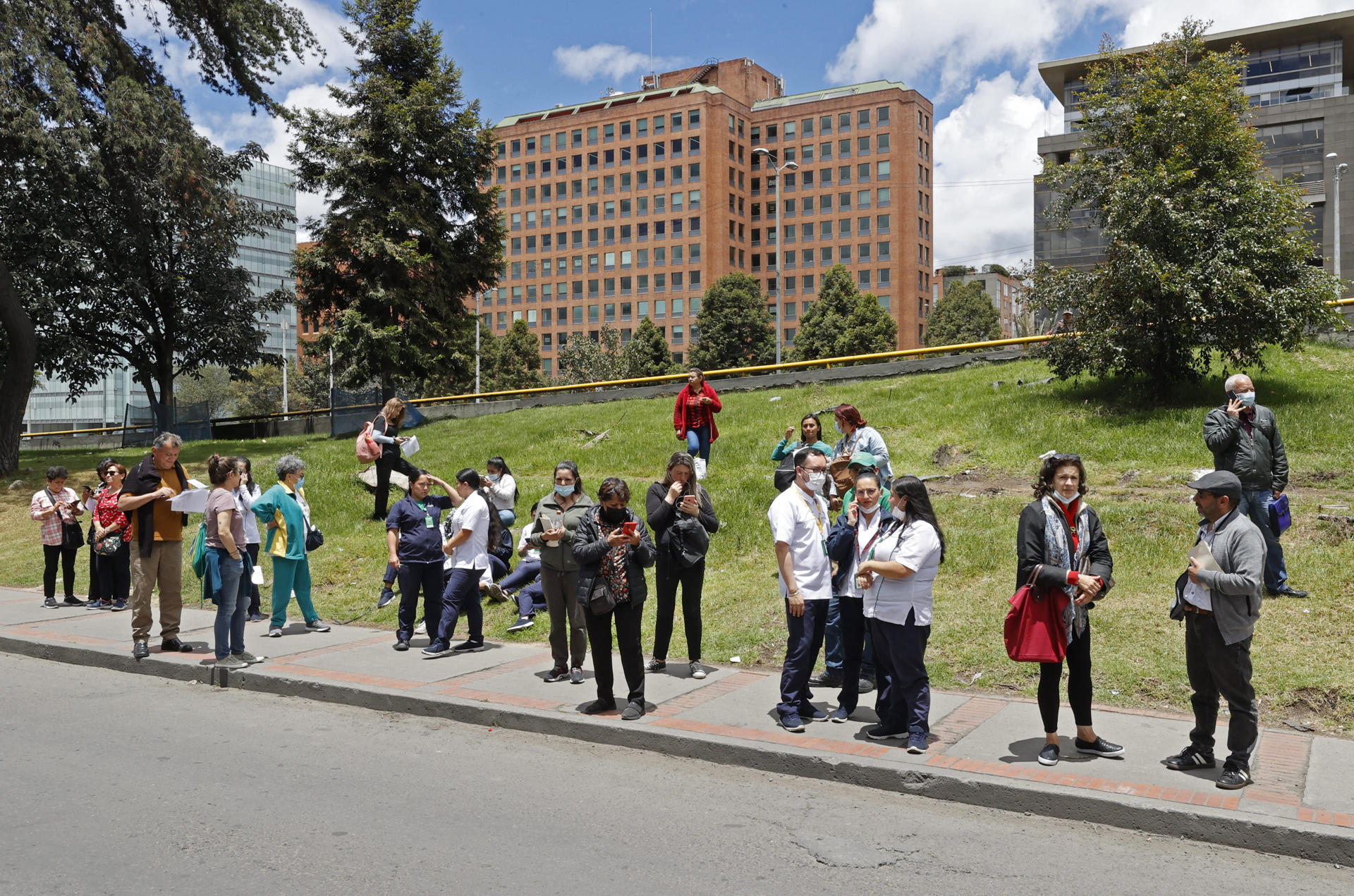 Personas se reúnen afuera de un edificio luego de ser evacuadas debido a un sismo de 6.1 hoy, en Bogotá (Colombia). EFE/Mauricio Dueñas Castañeda