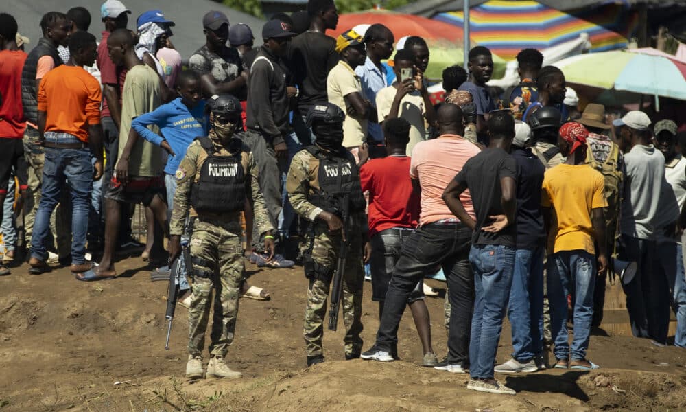 Policías haitianos escoltan a trabajadores durante la construcción de un canal de riego a orillas del río Masacre, en Ouanaminthe (Haití), en una fotografía de archivo. EFE/Orlando Barría