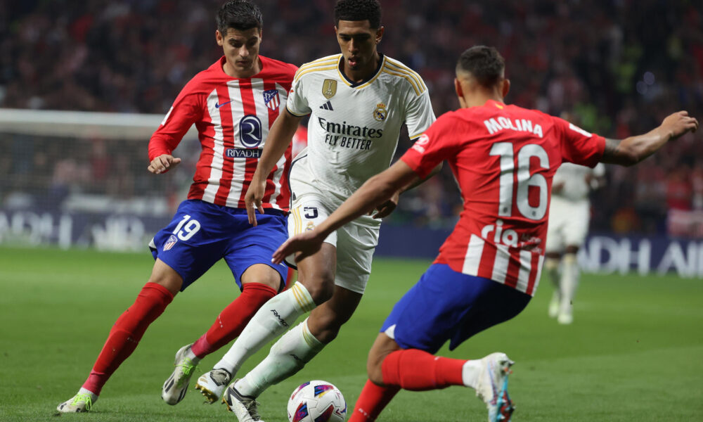 El delantero del Atlético de Madrid Álvaro Morata (i) y el defensa argentino Nahuel Molina disputan un balón ante el centrocampista británico Jude Bellingham (c) Real Madrid durante el partido de la sexta jornada de LaLiga. EFE/ Kiko Huesca