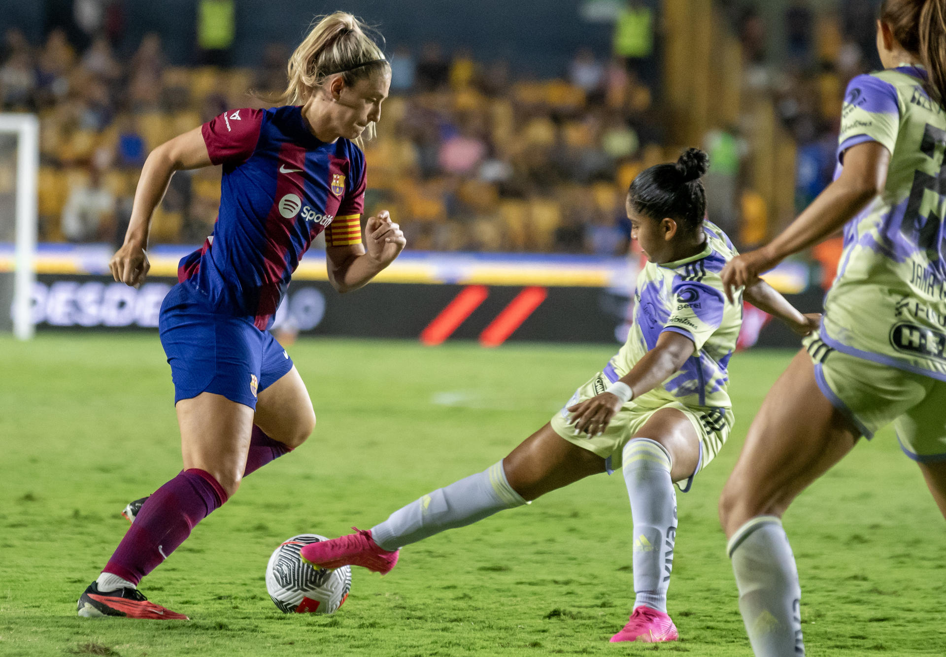 Belen Cruz (d) de Tigres femenil disputa el balón con Alexia Putellas de Barcelona hoy, en un amistoso internacional en el estadio Universitario de la ciudad de Monterrey (México). EFE/ Miguel Sierra