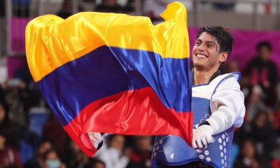 Fotografía de archivo en la que se registró al taekwondista colombiano Miguel Ángel Trejos, al ondear una bandera de su país durante los Juegos Panamericanos 2019, en Lima (Perú). EFE/Martín Alipaz