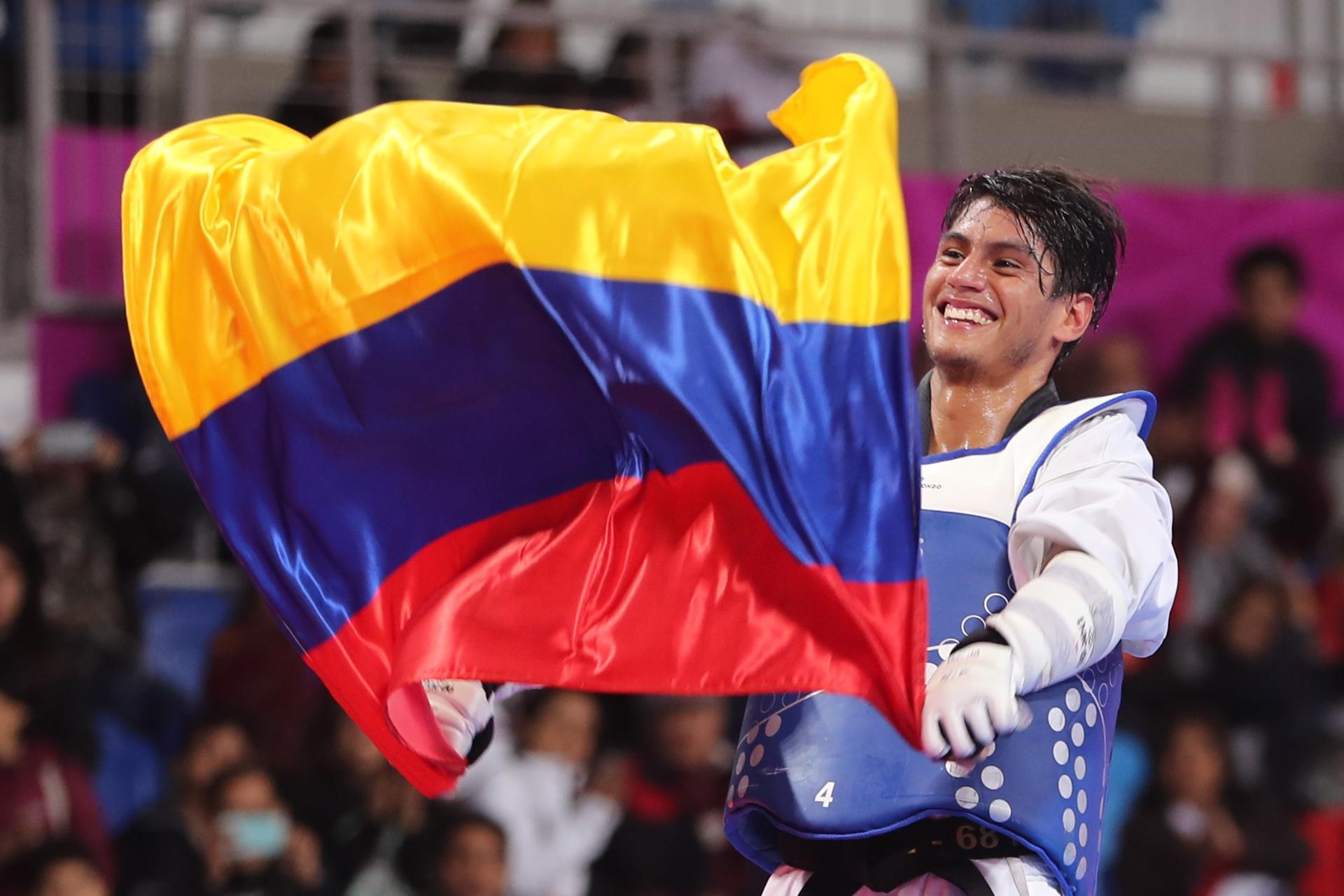 Fotografía de archivo en la que se registró al taekwondista colombiano Miguel Ángel Trejos, al ondear una bandera de su país durante los Juegos Panamericanos 2019, en Lima (Perú). EFE/Martín Alipaz