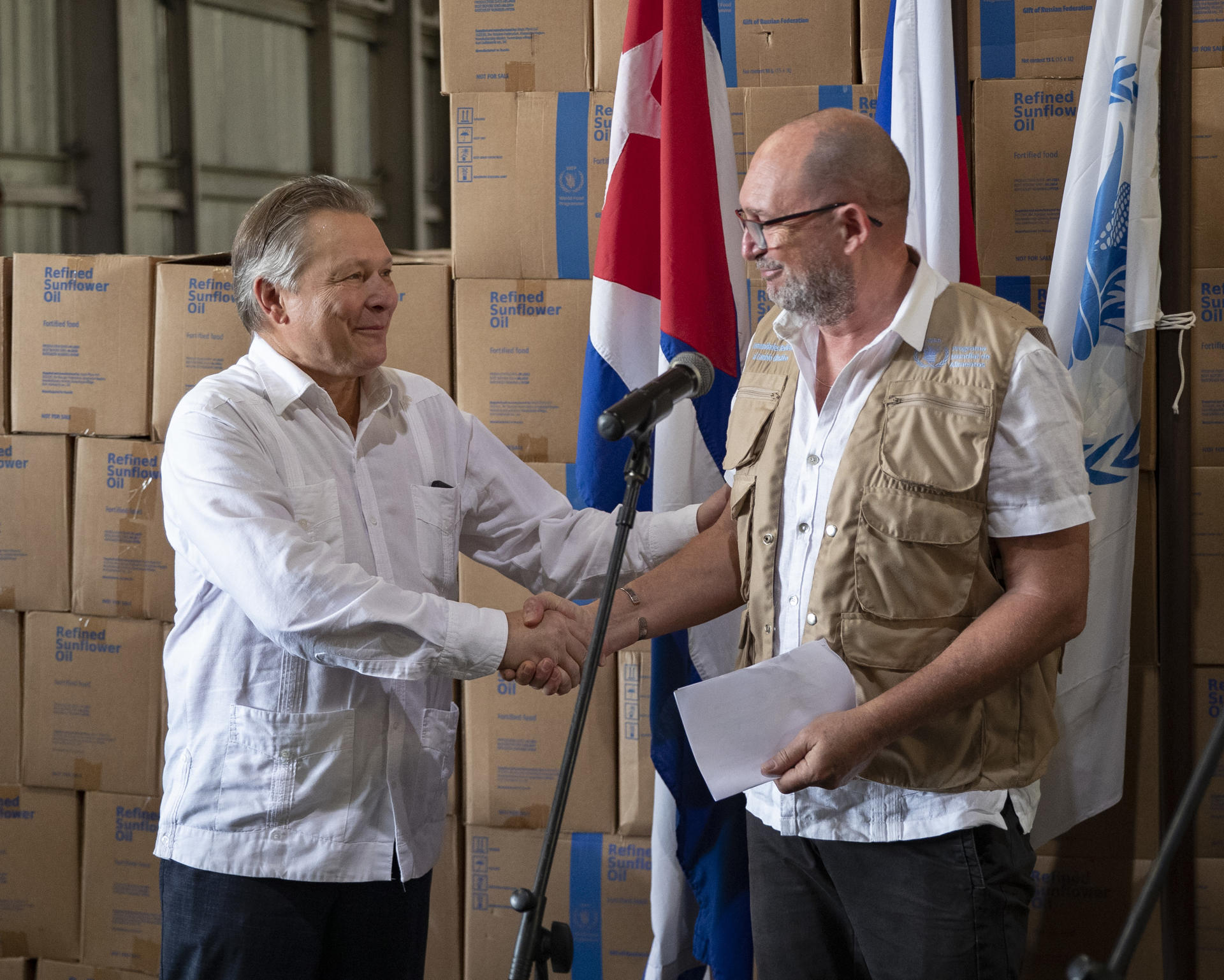 Etienne Labande (d), representante del Programa Mundial de Alimento (PMA) en Cuba, saluda a Victor Koronelli (i), embajador de Rusia en Cuba, durante la ceremonia de recepción de aceite vegetal donado por la federación Rusa, hoy, en La Habana (Cuba). EFE/ Yander Zamora