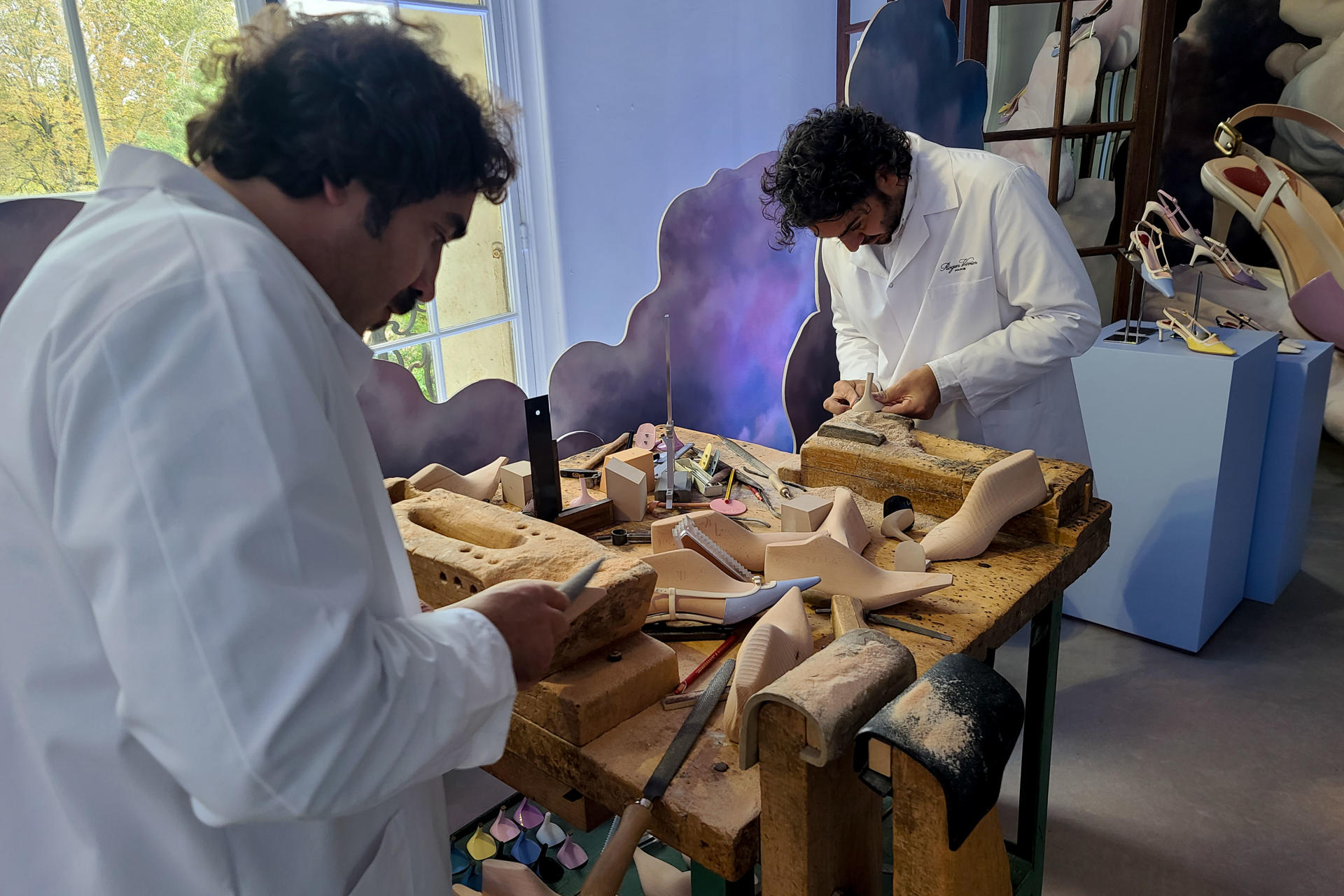 Dos hombres muestran el proceso de confección de los zapatos de la casa Roger Vivier, que presenta su nueva colección de calzado y bolsos durante la Semana de la Moda de París, este jueves en la capital francesa. EFE/ Edgar Sapiña Manchado
