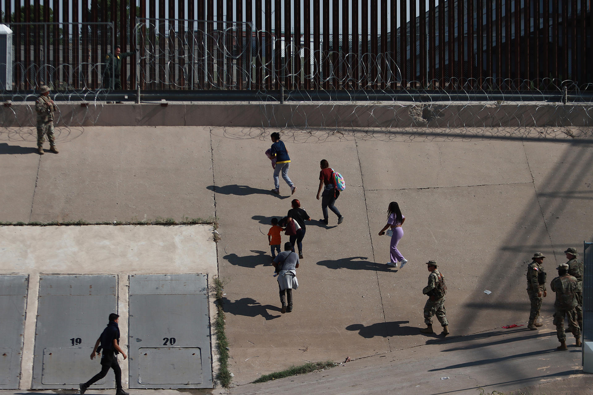 Miembros de la Guardia Nacional de Texas reciben a un grupo de migrantes, en la frontera de en Ciudad Juárez (México). Imagen de archivo. EFE/Luis Torres
