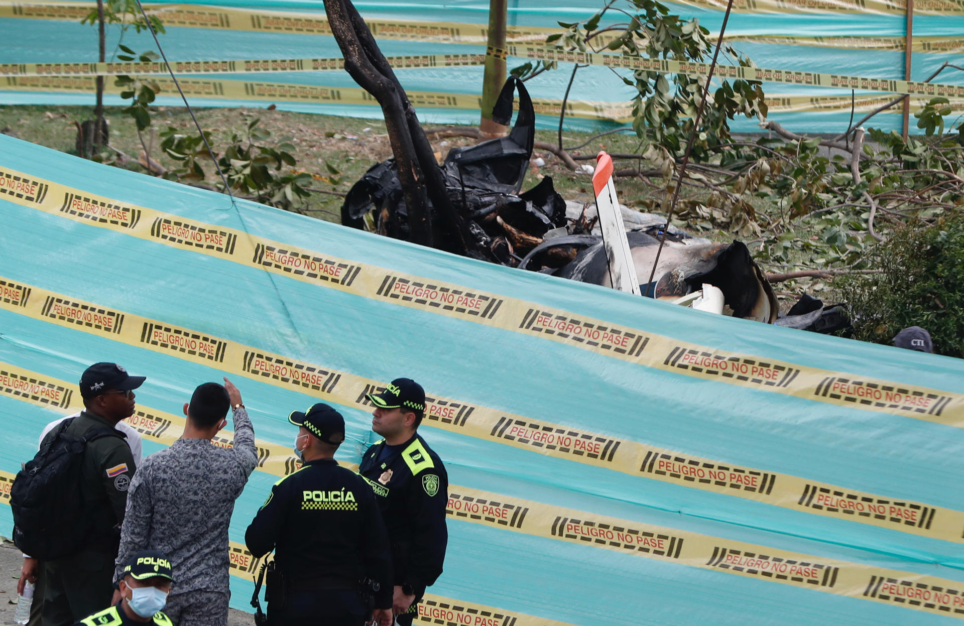 Miembros de la Policía fueron registrados este martes, 3 de octubre, al acordonar la zona donde se accidentó una aeronave de la Fuerza Aeroespacial Colombiana (FAC), en Cali (Colombia). EFE/Ernesto Guzmán