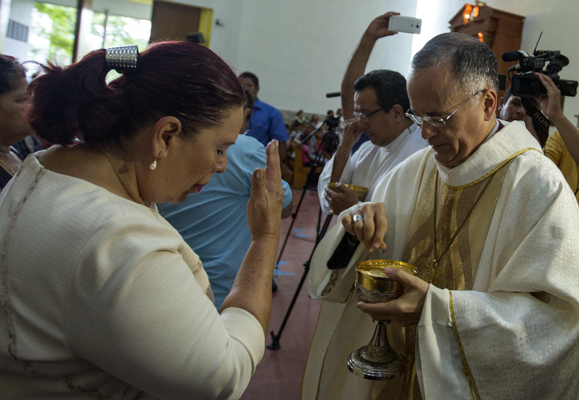 Fotografía de archivo en la que se registró al obispo auxiliar de Managua, Silvio José Báez (d), al repatir la comunión, en la capital nicaragüense. EFE/Jorge Torres