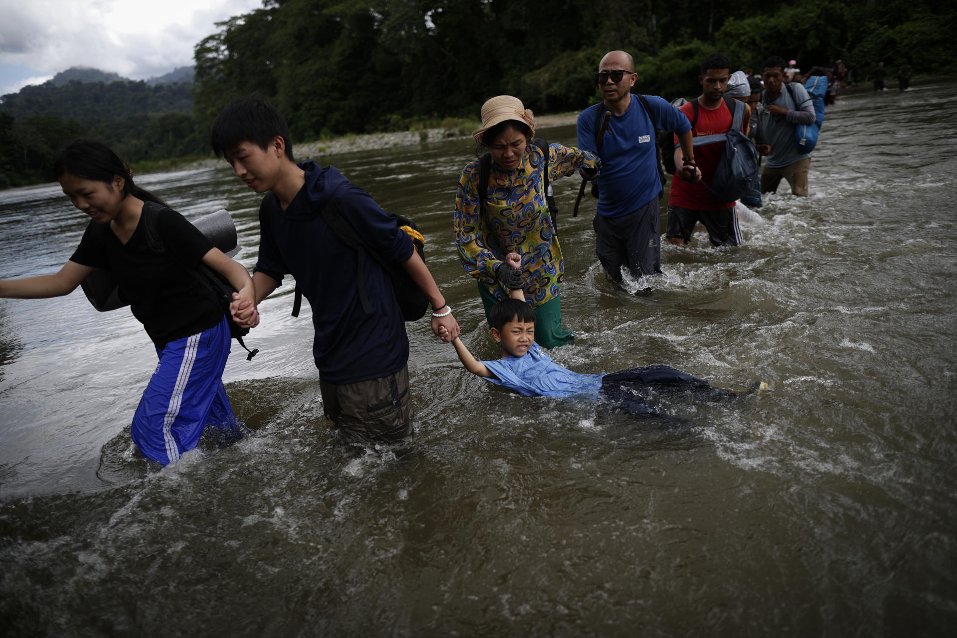 Migrantes cruzan el río Turquesa, en Darién (Panamá). EFE/Bienvenido Velasco