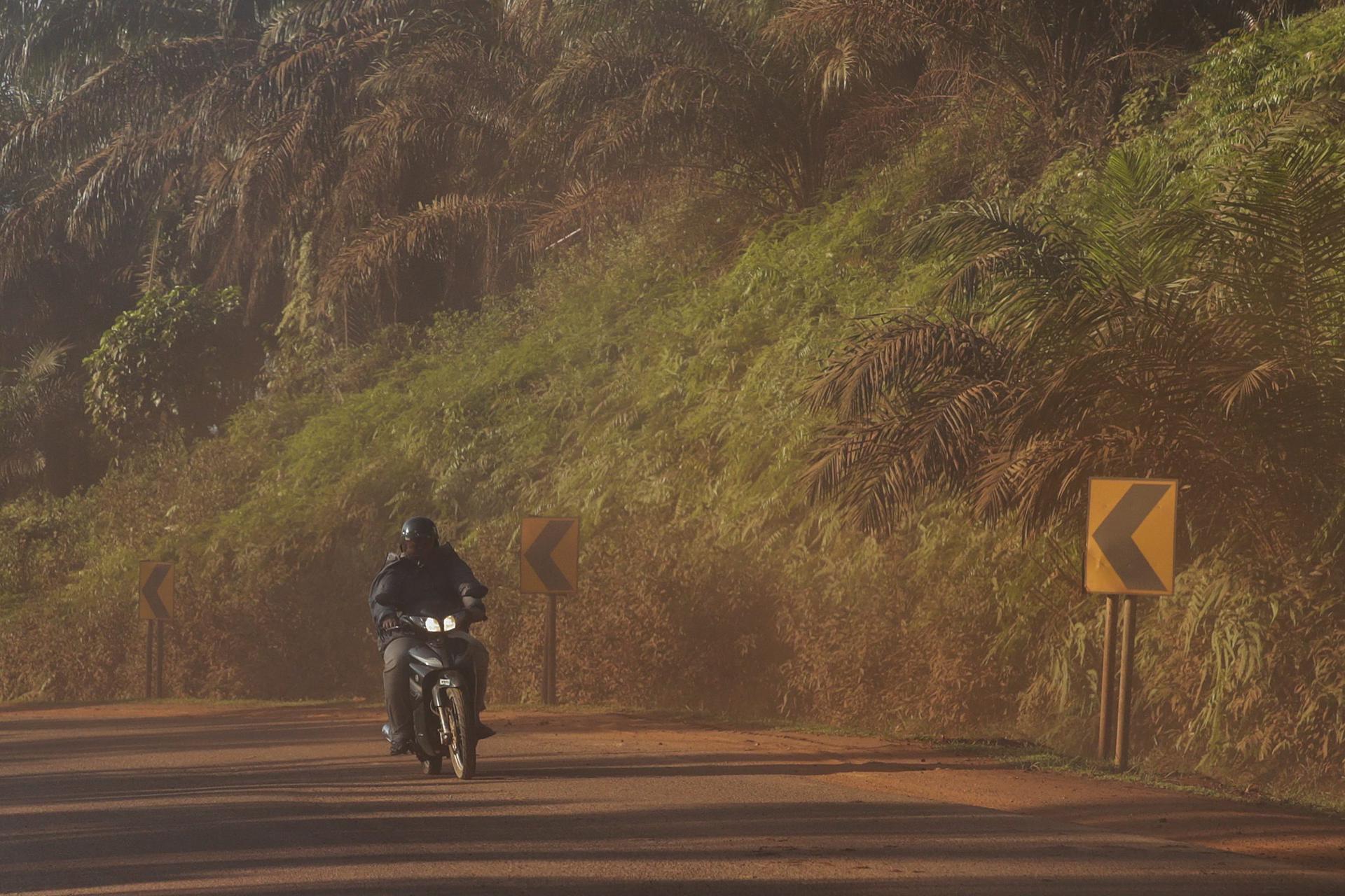 Un motociclista circula por una carretera cubierta de polvo debido a la contaminación en Kuantan (Malasia), en una imagen de archivo. EFE/Fazry Ismail