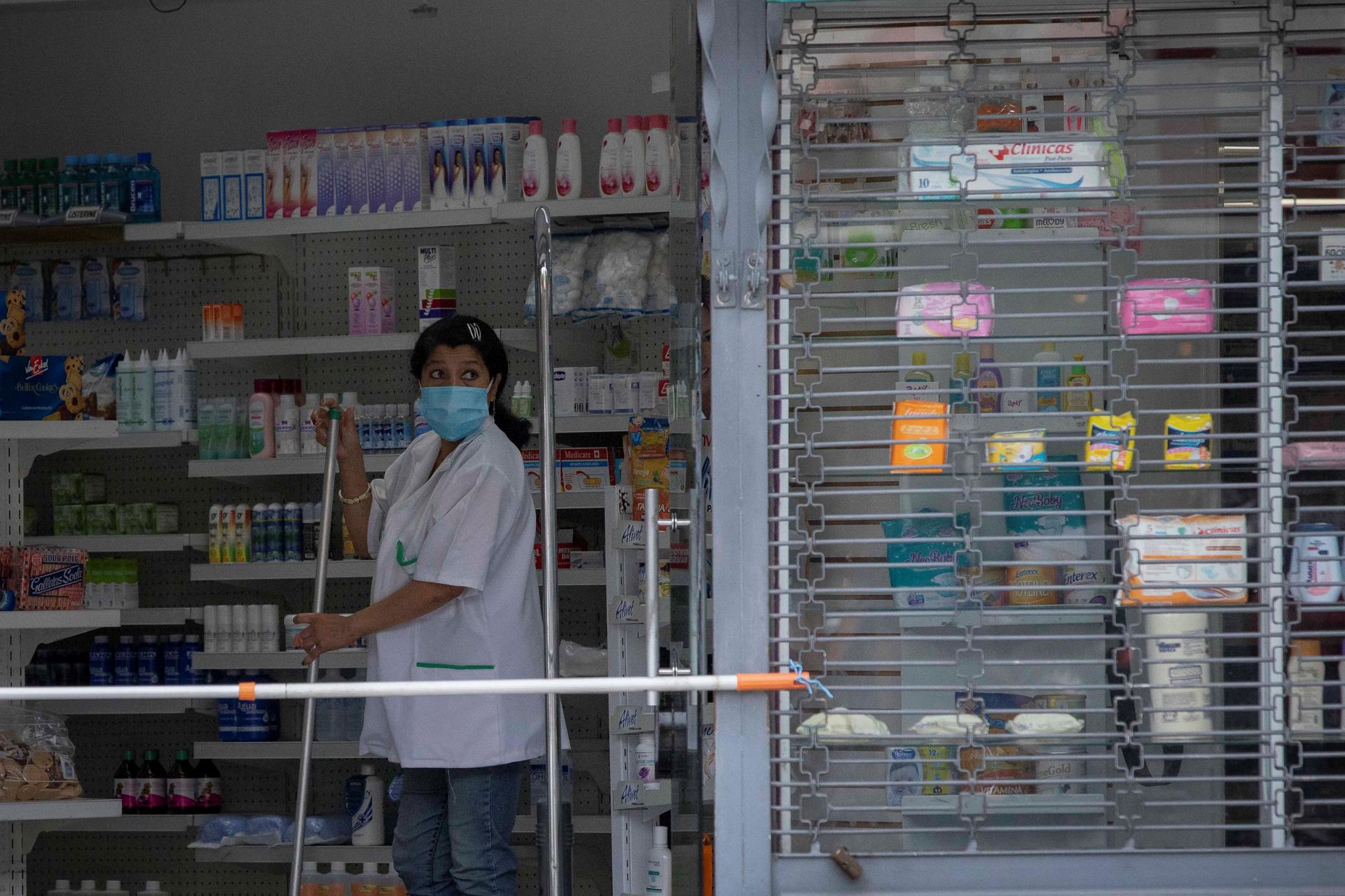 La trabajadora de una farmacia observa el mostrador en Caracas, en una fotografía de archivo. EFE/RAYNER PEÑA R.