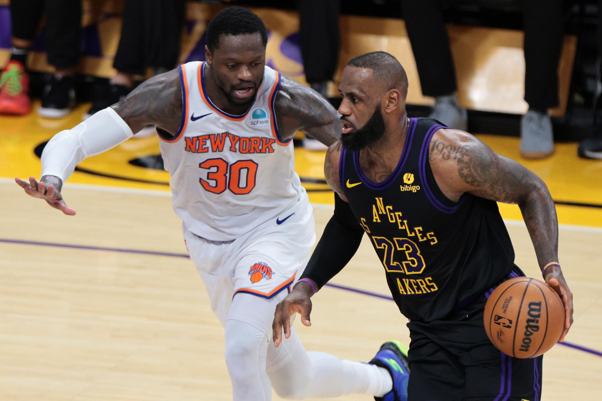 El juagador de los Angeles Lakers LeBron James (d) regatea el balón pasando por Julius Randle de los New York Knicks durante la primera mitad del partido de baloncesto de la NBA.EFE/EPA/ALLISON CENA