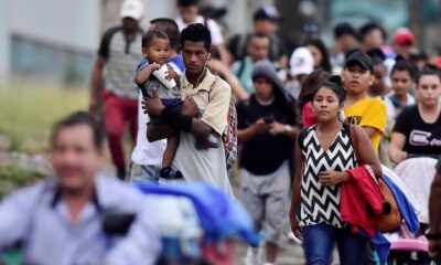 Fotografía de archivo de un padre que carga a su hijo mientras camina junto a la caravana migrante, rumbo a la frontera guatemalteca de Agua Caliente, a su paso por San Pedro Sula (Honduras). EFE/José Valle