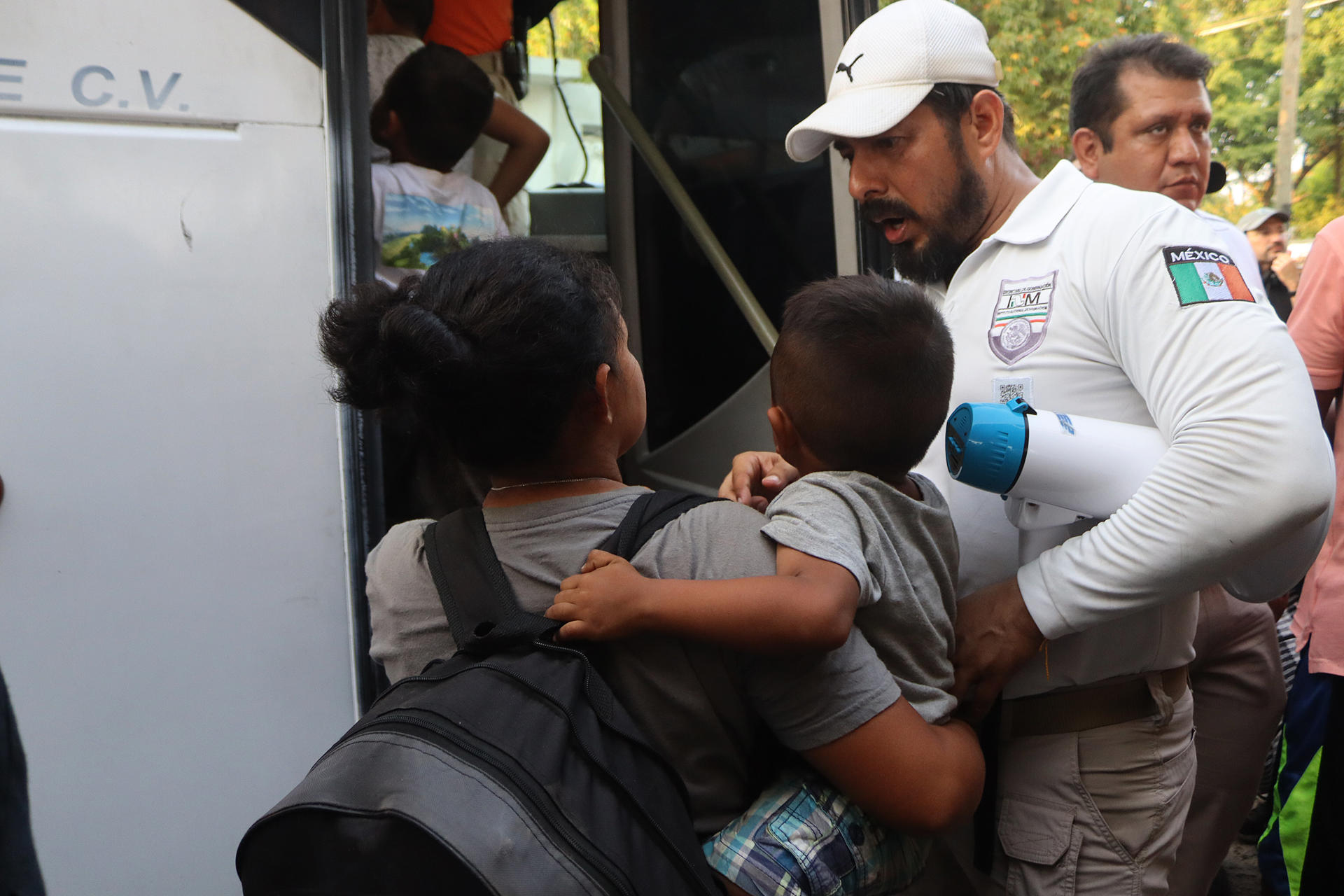 Una migrante con su hijo conversa con un oficial del Instituto Nacional de Migración (INM) antes de abordar un autobús hoy, luego de finalizada una caravana rumbo a Estados Unidos, en el municipio de Mapastepec, estado de Chiapas (México). EFE/ Juan Manuel Blanco