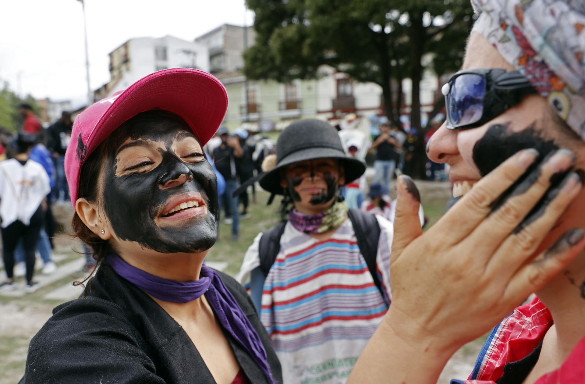 Una mujer pinta el rostro de otra durante el denominado 'Día de negritos' del Carnaval de Negros y Blancos, hoy, en Pasto (Colombia).  EFE/Mauricio Dueñas Castañeda