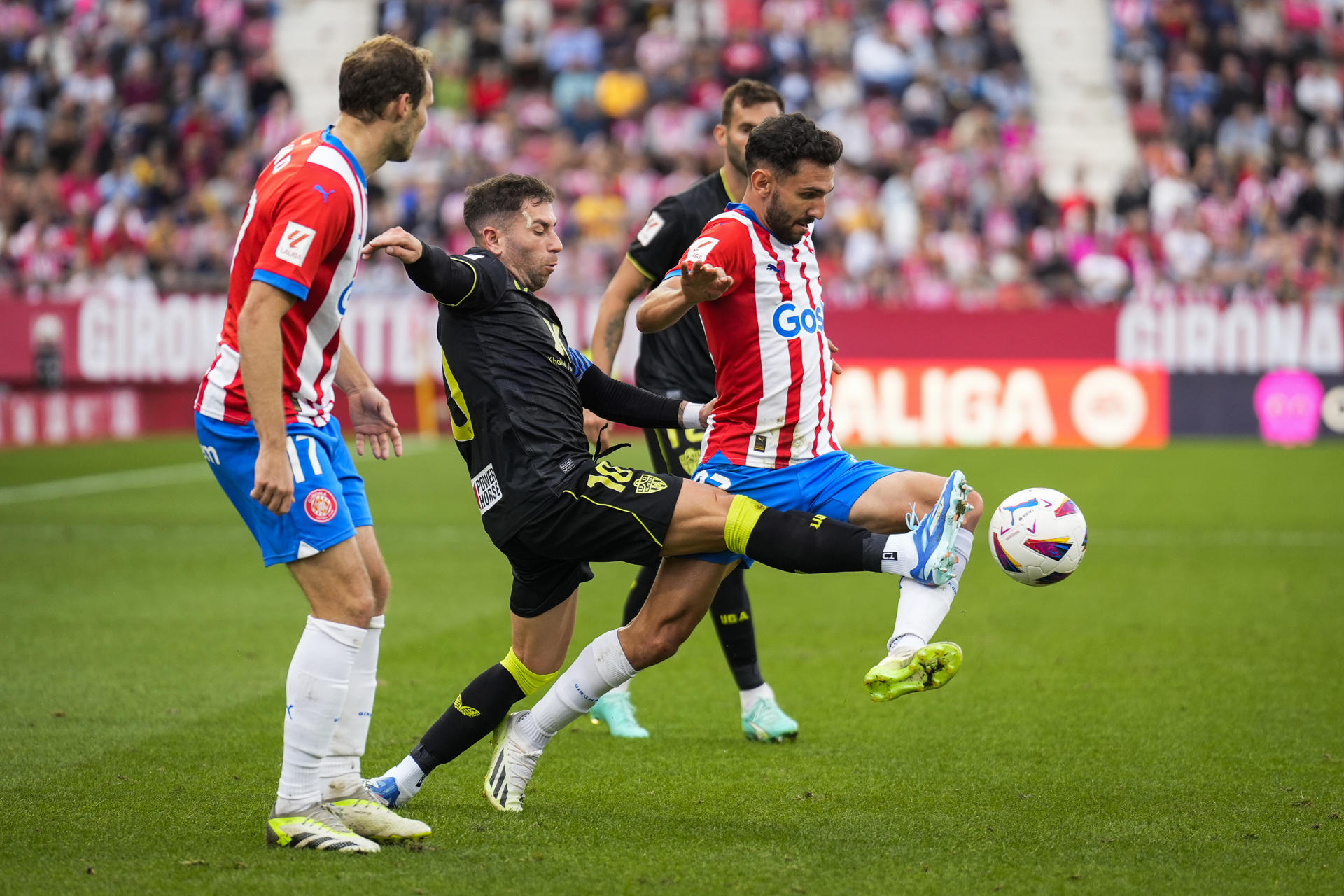 El delantero del Girona Ivan Martín (d) supera al centrocampista del Almería Adrián Embarba, durante el partido de Liga en Primera División en el estadio municipal de Montilivi en foto de archivo de David Borrat. EFE