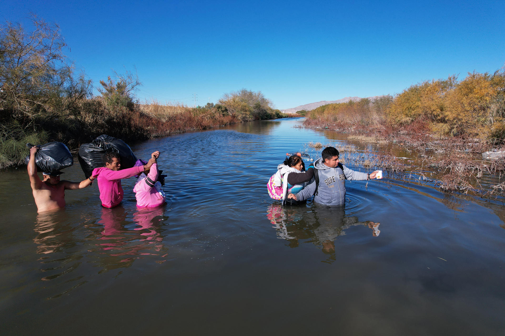 Migrantes cruzan el Río Bravo en las cercanías del muro que separa la frontera estadounidense, el 29 de diciembre de 2023, en Ciudad Juárez, Chihuahua (México). EFE/ Luis Torres