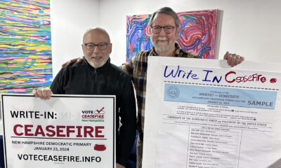 Andreu Volinsky (i), y Bill Maddocks (d), profesores universitarios, posan con carteles que invitan a escribir la palabra 'cese al fuego' en las tarjetas de votación, el sábado 20 de enero de 2024, en Concord, Nuevo Hampshire (Estados Unidos). EFE/ Octavio Guzmán