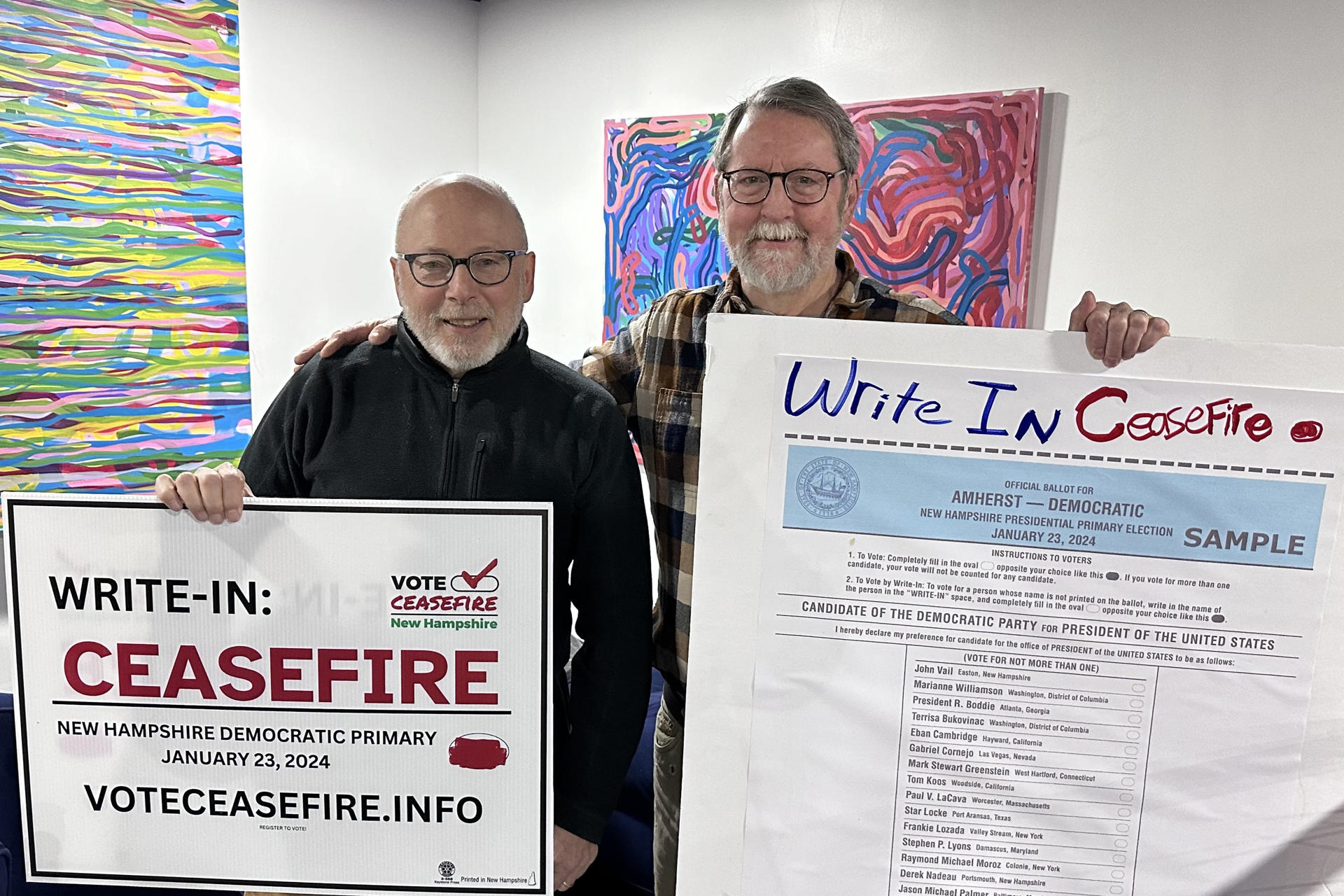 Andreu Volinsky (i), y Bill Maddocks (d), profesores universitarios, posan con carteles que invitan a escribir la palabra 'cese al fuego' en las tarjetas de votación, el sábado 20 de enero de 2024, en Concord, Nuevo Hampshire (Estados Unidos). EFE/ Octavio Guzmán