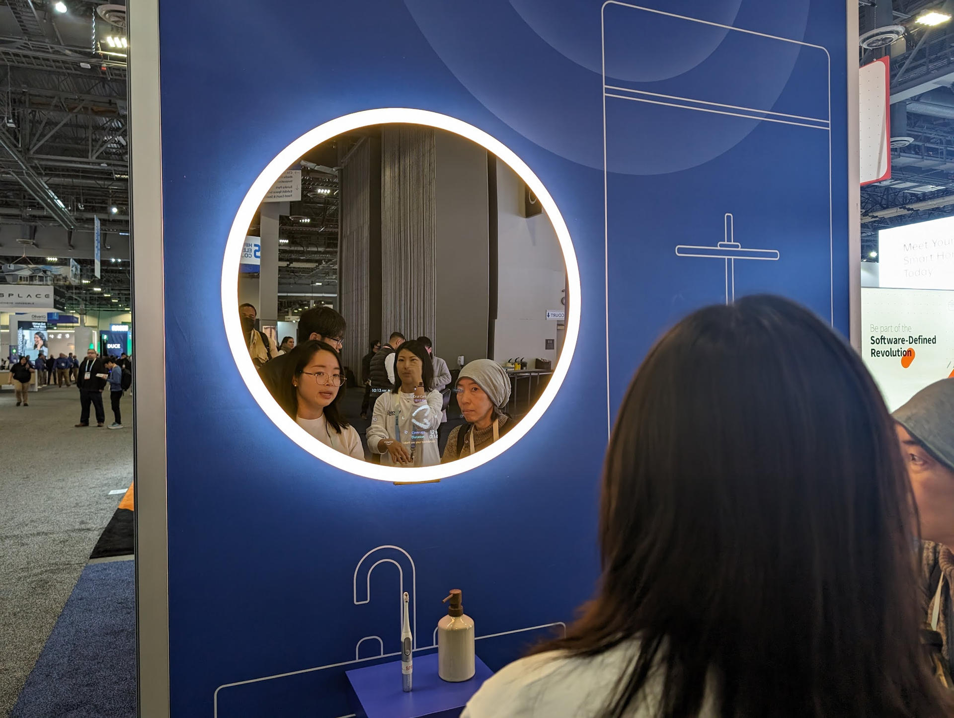 Personas observan hoy el espejo de Baracoda, que usa la IA generativa para aumentar la confianza de los usuarios y su estado de ánimo con mensajes positivos y meditaciones, en la feria tecnológica CES 2024 en Las Vegas, Nevada (EE.UU). EFE/ Sarah Yáñez-Richards