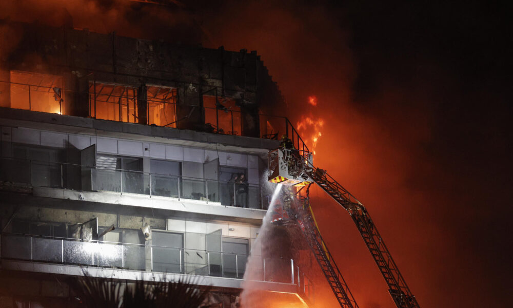 Vista del incendio declarado sobre las cinco y media de esta tarde en un quinto piso de un edificio de viviendas de València que ha afectado totalmente al inmueble y se ha propagado a otro anexo, y los bomberos intentan aún rescatar a vecinos desde los balcones. EFE/Manuel Bruque