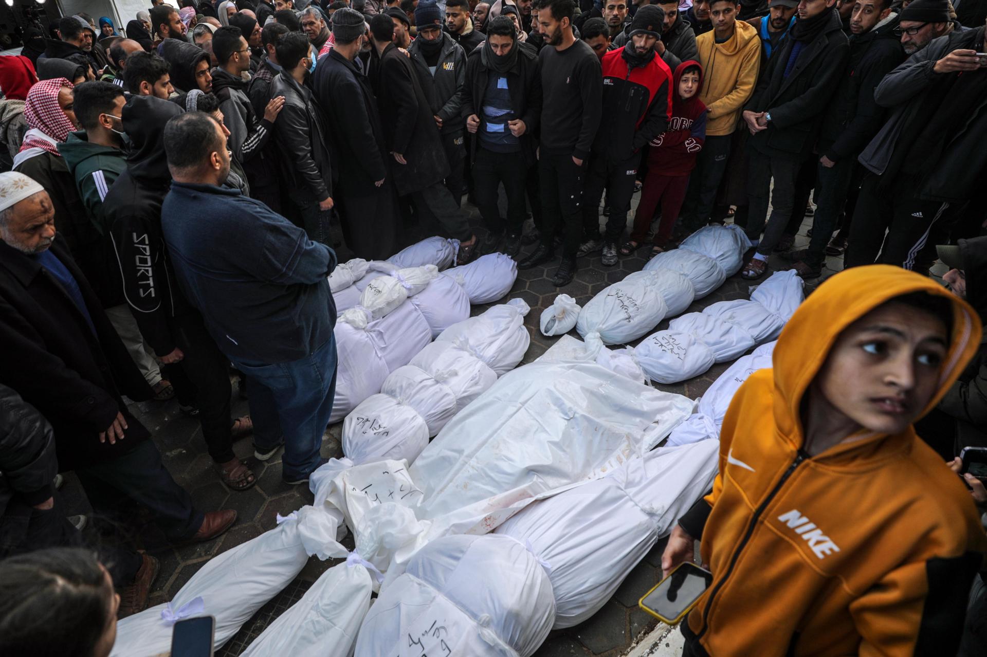 La gente se reúne alrededor de los cuerpos de una familia muerta durante un ataque aéreo israelí en la ciudad de Deir Al Balah, al sur de la Franja de Gaza, el 5 de febrero de 2024. EFE/EPA/Mohammed Saber
