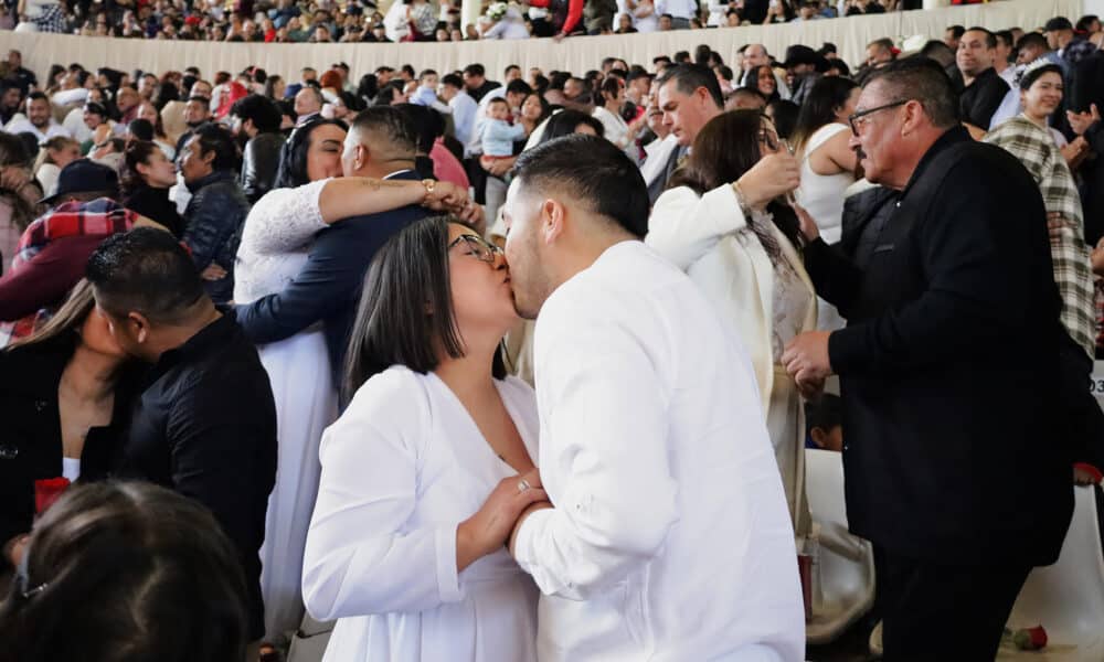 Parejas se besan al contraen matrimonio este miércoles durante una boda colectiva en la ciudad de Tijuana, Baja California (México). EFE/Joebeth Terriquez