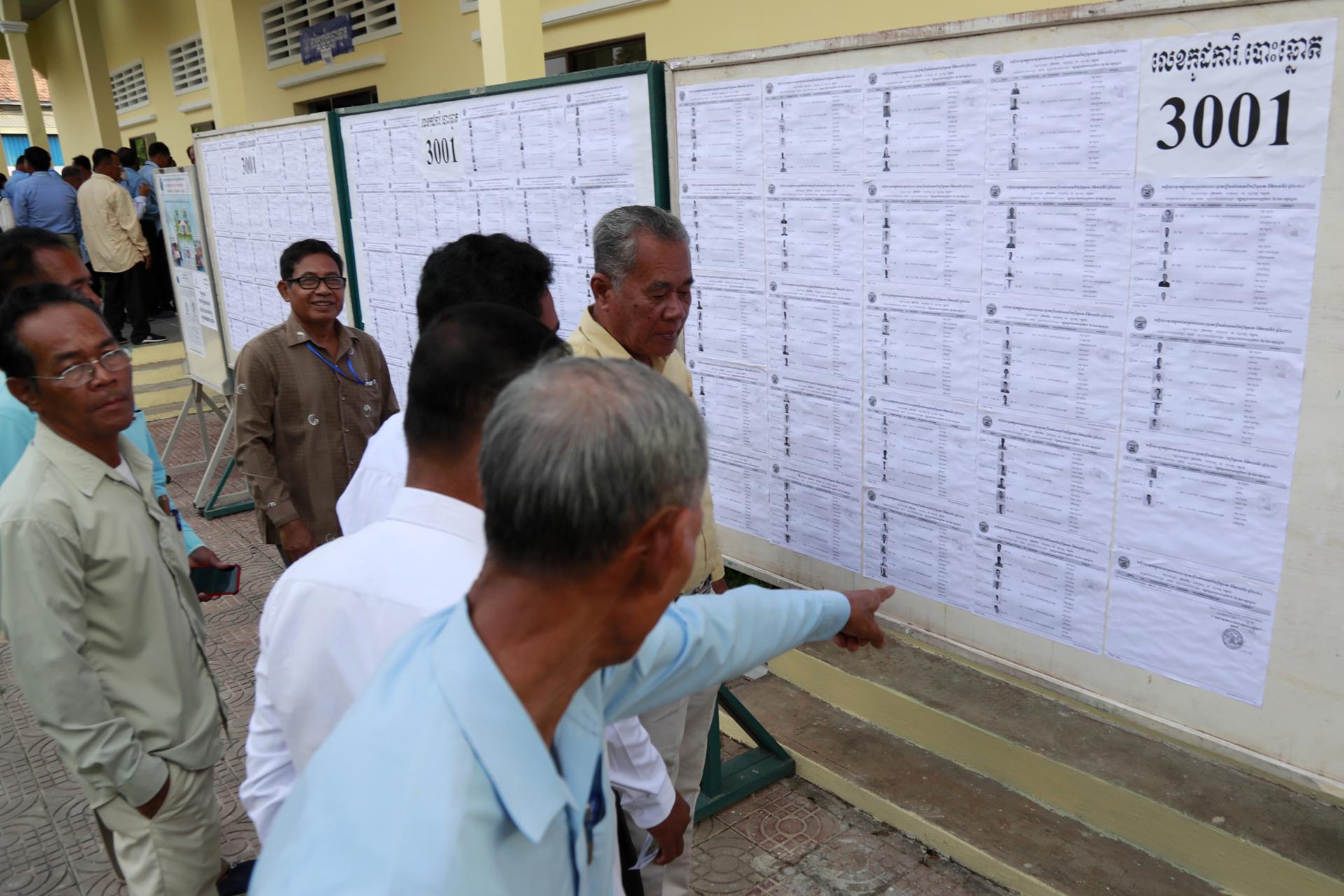 Funcionarios camboyanos comprueban una lista de nombres de votantes para las elecciones al Senado en un colegio electoral de la provincia de Kandal. EFE/EPA/KITH SEREY