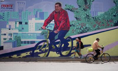Personas pasan frente a un mural del ex presidente fallecido Hugo Chávez en Caracas (Venezuela). EFE/ Rayner Peña R.