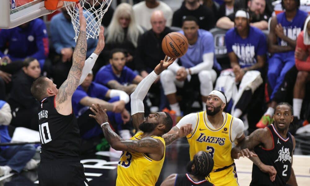 El jugador de los Angeles Lakers LeBron James (2-I) lanza la pelota a canasta con la oposición del jugador de los Angeles Clippers Daniel Theis (i) durante la segunda mitad del partido de baloncesto de la NBA entre los Angeles Lakers y Los Angeles Clippers en Los Ángeles, California, EE. UU. EFE/EPA/ALLISON DINNER