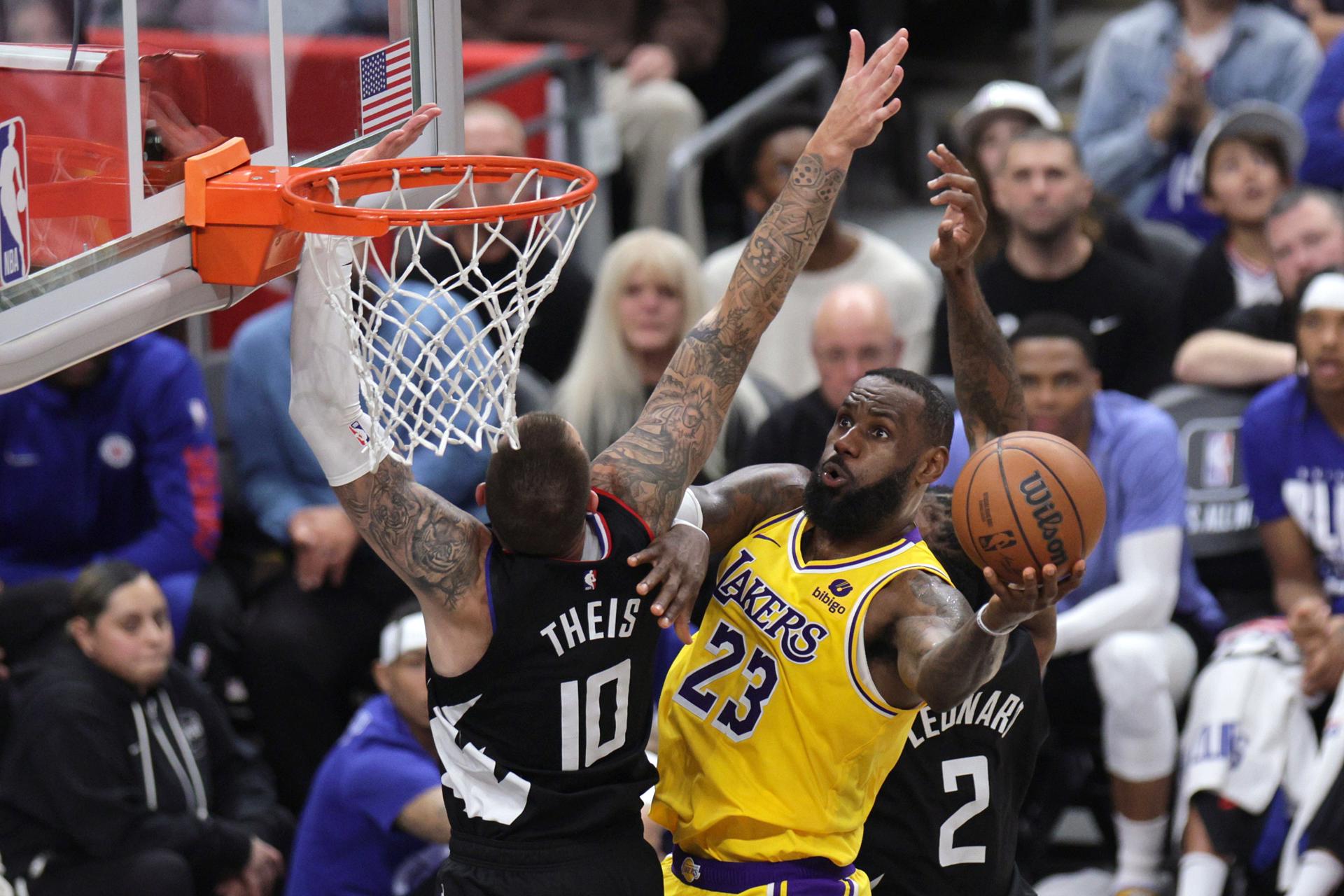 El jugador de Los Angeles Lakers, LeBron James (d) entra a canasta durante la segunda mitad del partido de baloncesto de la NBA entre Los Angeles Lakers y Los Angeles Clippers en Los Ángeles, California, Estados Unidos. EFE/EPA/ALLISON DINNER