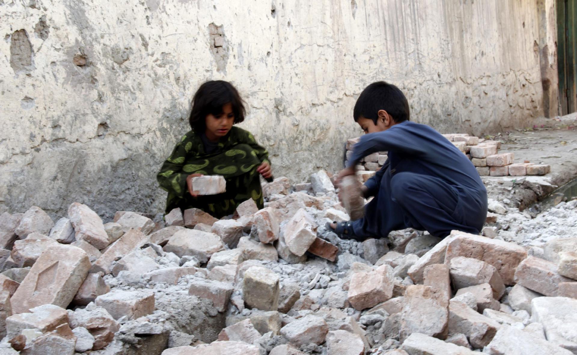 En la imagen de archivo, dos niños juegan con los escombros de su casa tras el terremoto de magnitud 5,6 grados en Nangarhar, Afganistán. EFE/Abdul Mueed