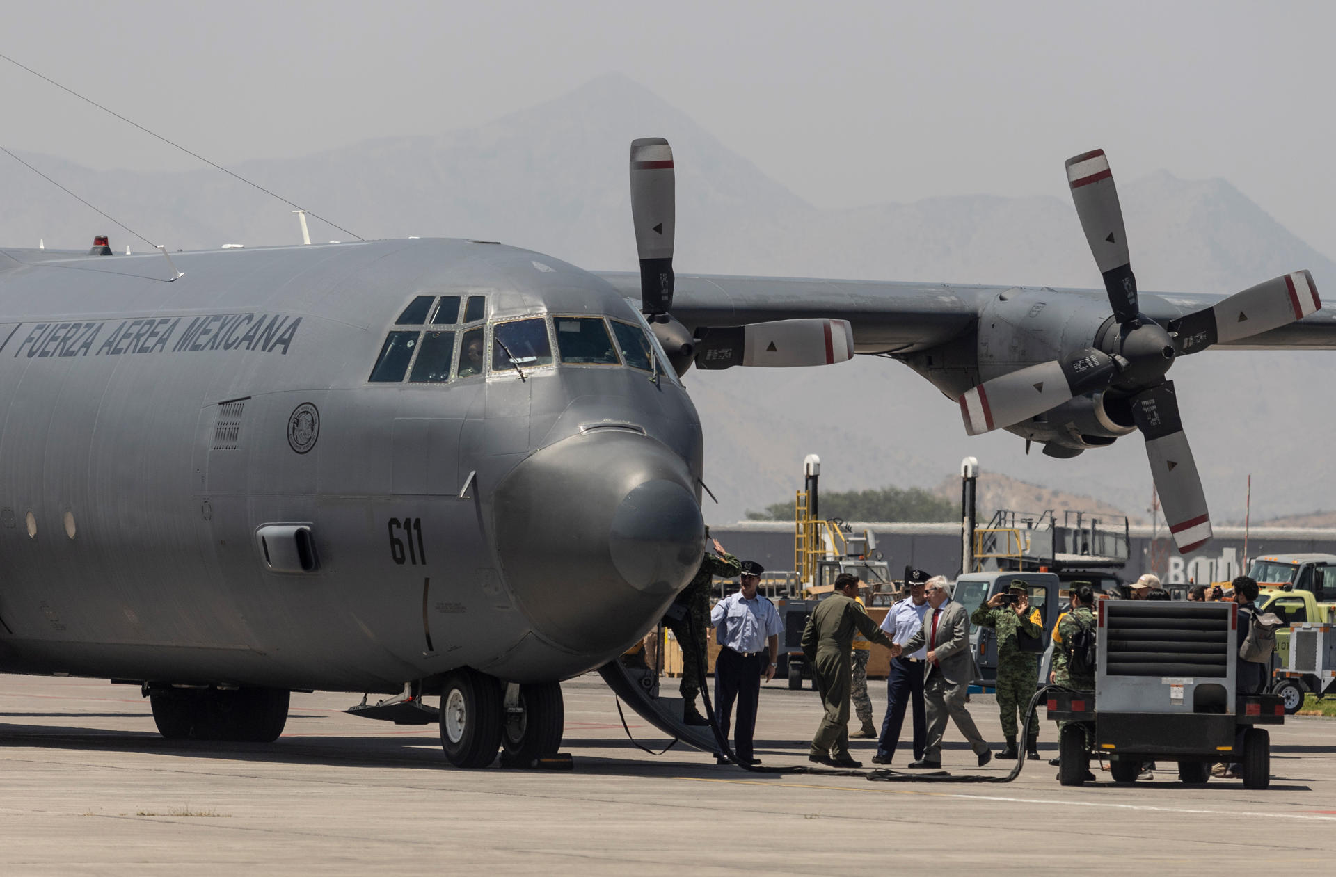 El ministro de Relaciones Exteriores de Chile, Alberto van Klaveren (c), saluda a la tripulación a bordo de un avión de la Fuerza Aérea de México que aterrizó hoy con ayuda humanitaria, en el Grupo 10 de la Fuerza Aérea de Chile (FACh), en Santiago (Chile). EFE/ Ailen Díaz