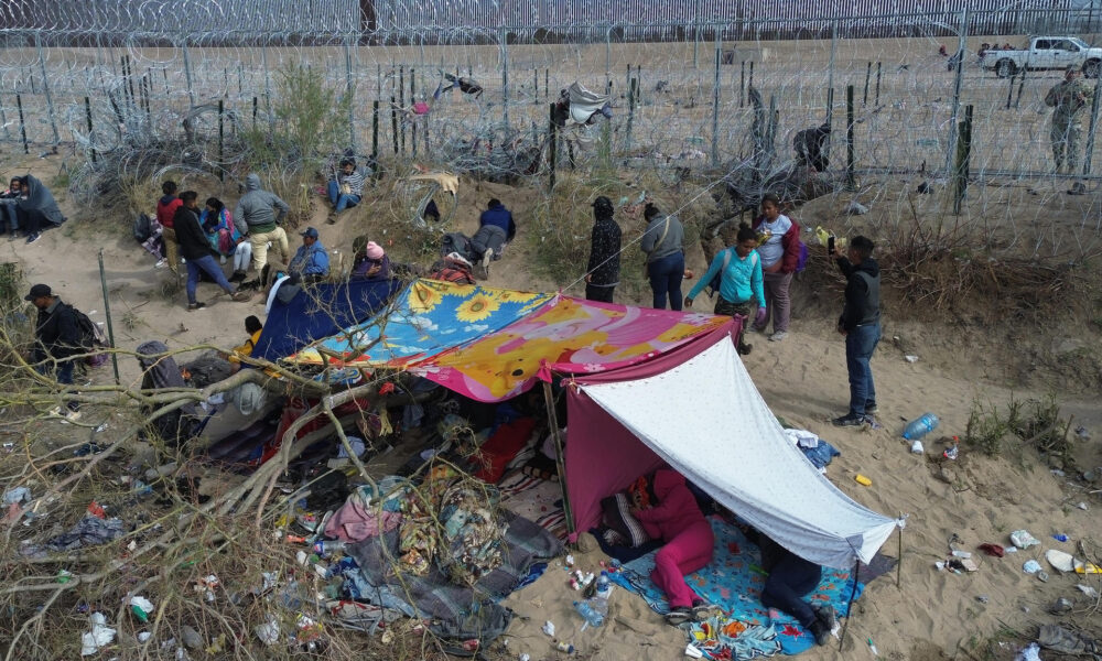 Migrantes permanecen en las inmediaciones del Río Bravo, junto al alambrado que divide a México con Estados Unidos, este miércoles, en Ciudad Juárez (México). EFE/ Luis Torres