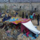 Migrantes permanecen en las inmediaciones del Río Bravo, junto al alambrado que divide a México con Estados Unidos, este miércoles, en Ciudad Juárez (México). EFE/ Luis Torres
