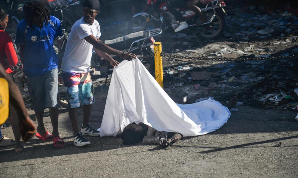 Un hombre cubre el cadáver de una persona en el suelo este lunes, en Puerto Príncipe (Haití). EFE/ Johnson Sabin