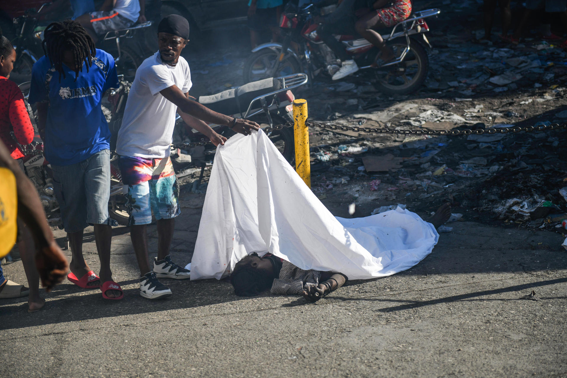 Un hombre cubre el cadáver de una persona en el suelo este lunes, en Puerto Príncipe (Haití). EFE/ Johnson Sabin
