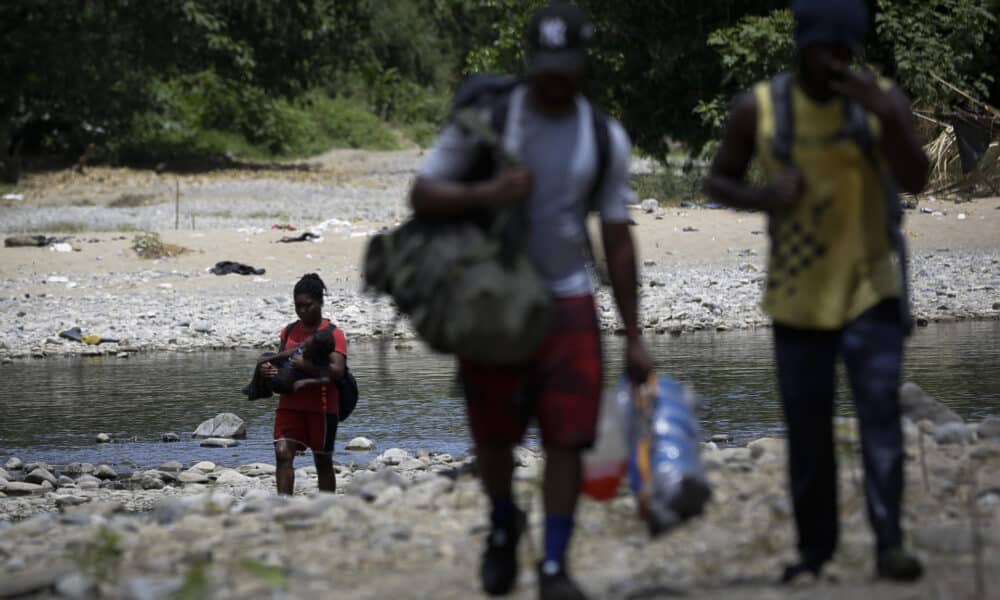 Personas migrantes cruzan el río Tuquesa en Darién (Panamá), en una fotografía de archivos. EFE/ Bienvenido Velasco