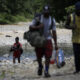 Personas migrantes cruzan el río Tuquesa en Darién (Panamá), en una fotografía de archivos. EFE/ Bienvenido Velasco