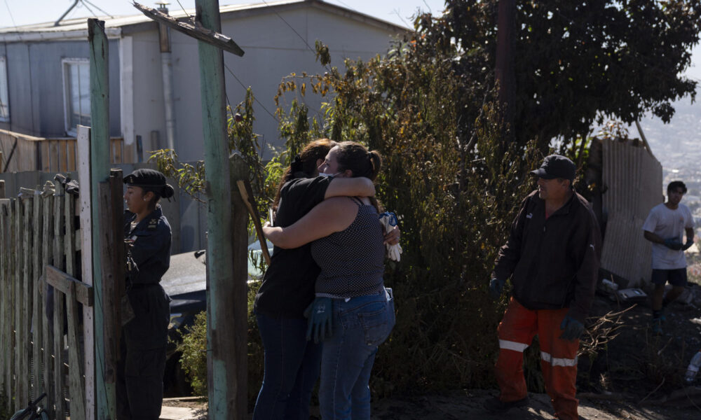 Personas se abrazan este jueves tras el incendio que afectó la noche del miércoles 13 de marzo al Cerro Cordillera en Valparaíso (Chile). EFE/Adriana Thomasa