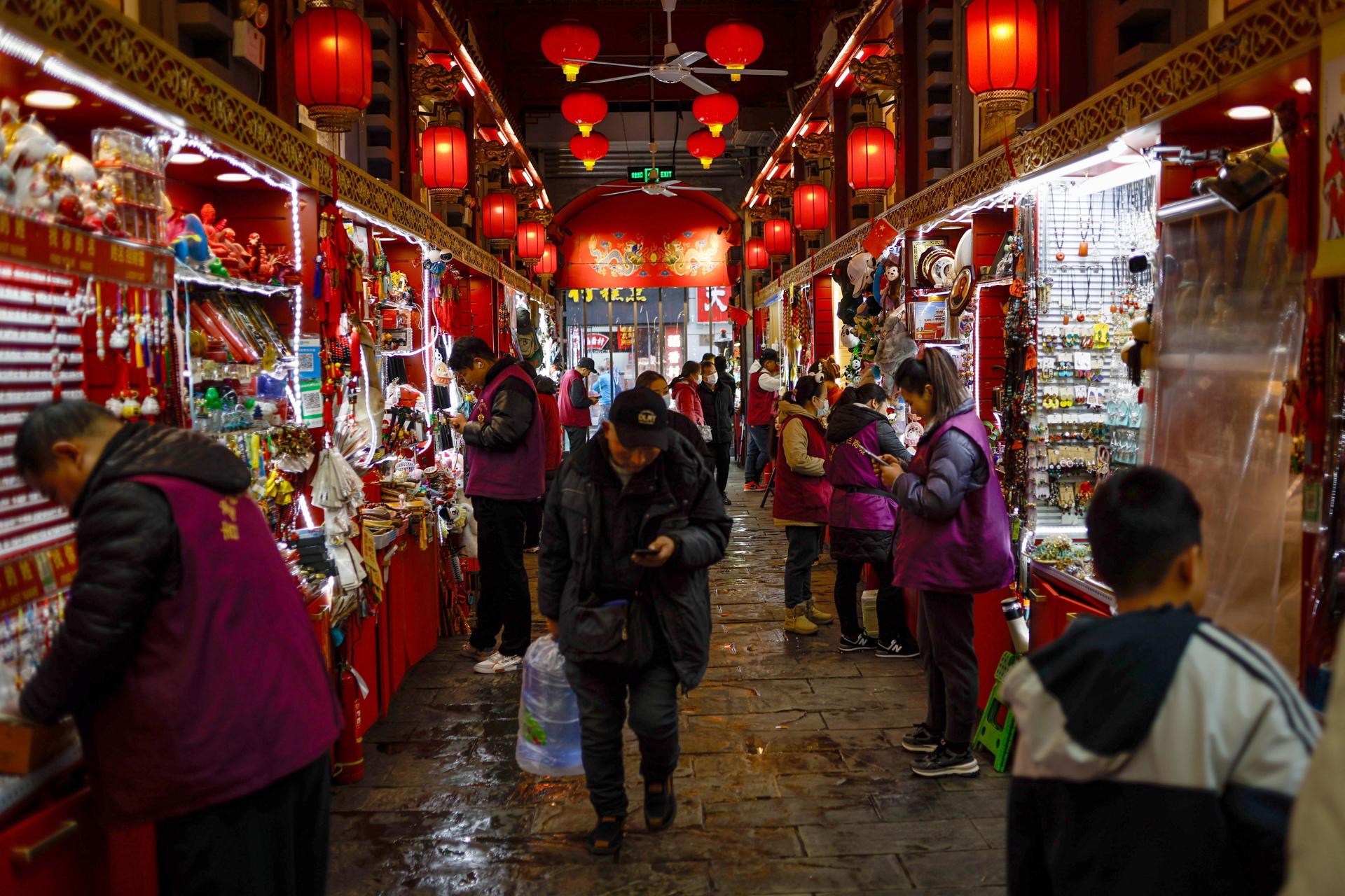 Personas caminan por una zona comercial de Pekín, en una fotografía de archivo. EFE/EPA/Mark R. Cristino
