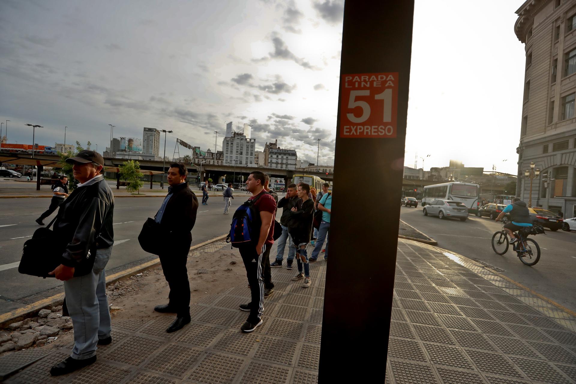 Pasajeros esperan en una parada de autobús, en una fotografía de archivo. EFE/Juan Ignacio Roncoroni