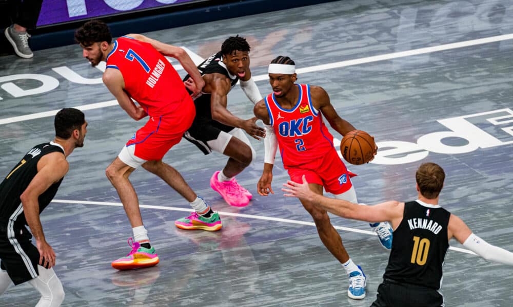 El canadiense Shai Gilgeous-Alexander (2-d), base de los Thunder Oklahoma City, fue registrado este sábado, 16 de marzo, al intentar superar la defensa de los Grizzlies de Memphis, durante un partido de la NBA, en el coliseo FedEx Forum, en Memphis (Tennessee, EE.UU.). EFE/Matthew Smith