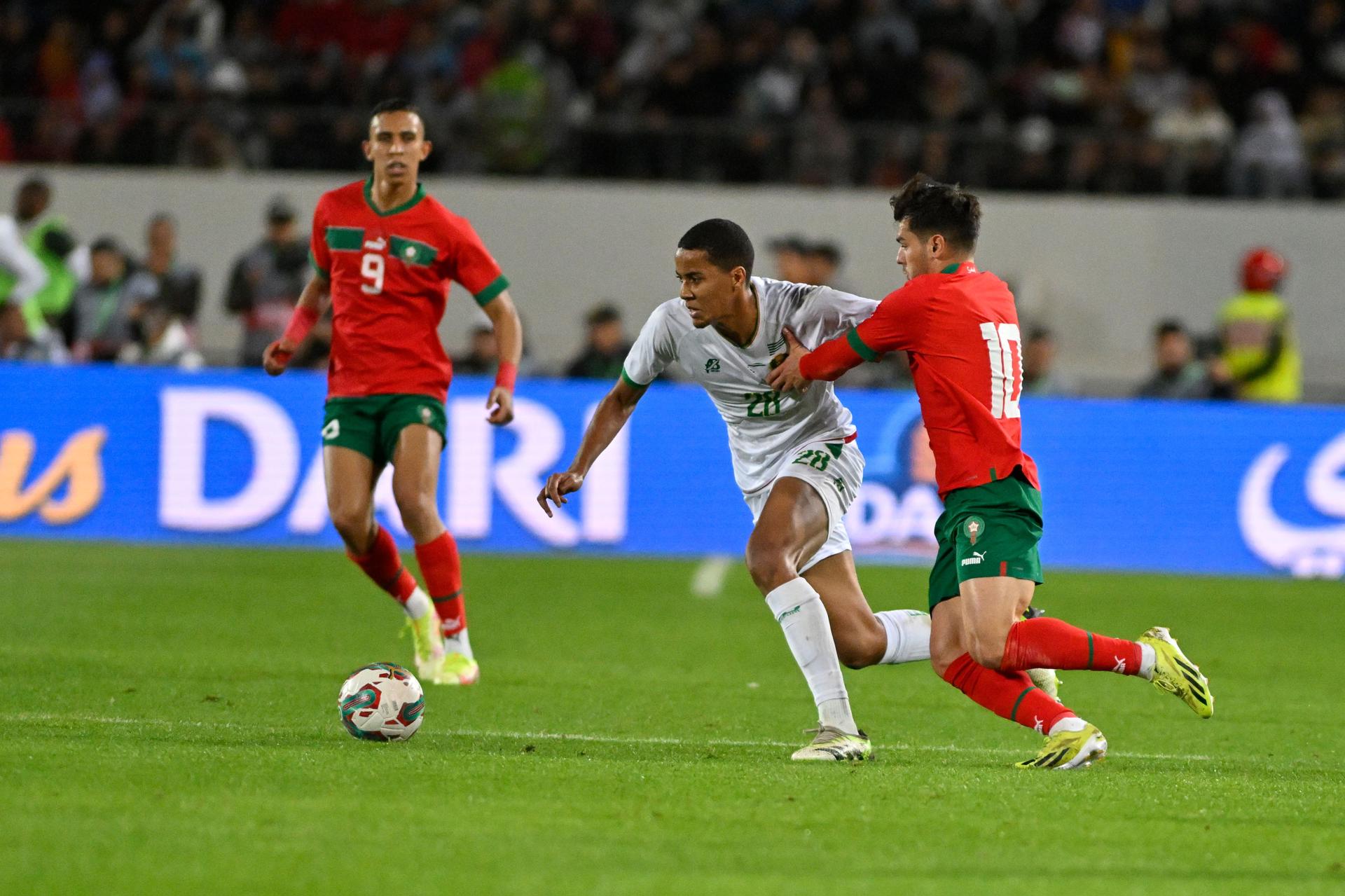 Brahim Díaz (d), de Marruecos, fue registrado este martes, 26 de marzo, al disputar un balón con Omar Ngom (c), de Mauritania, durante un partido amistoso jugado en la ciudad marroquí de Agadir. EFE/EPA/Jalal Morchidi