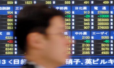 Fotografía de archivo en la que se registró el perfil de un hombre al pasar junto a una pantalla que muestra el índice Nikkei de la bolsa de Tokio (Japón). EFE/Andy Rain