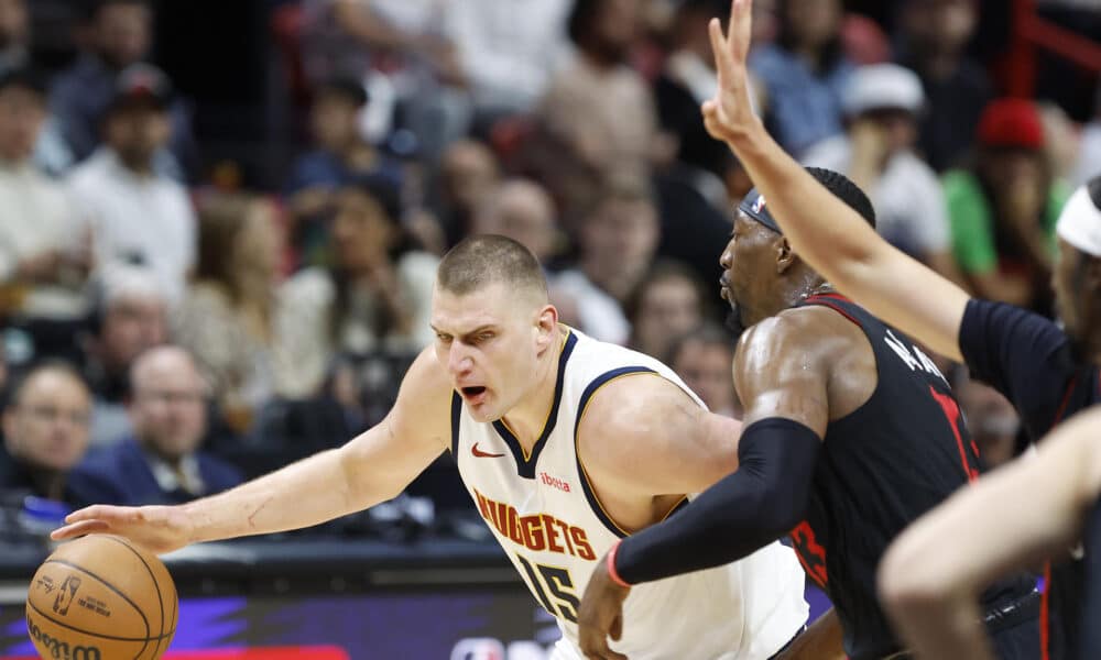 Bam Adebayo (d), ala pívot de los Heat de Miami, fue registrado este miércoles, 13 de marzo, al intentar impedir el avance de Nikola Jokic, pívot serbio de los Nuggets de Denver, durante un partido de la NBA, en el coliseo Kaseya Center, en Miami (Florida, EE.UU.). EFE/Rhona Wise