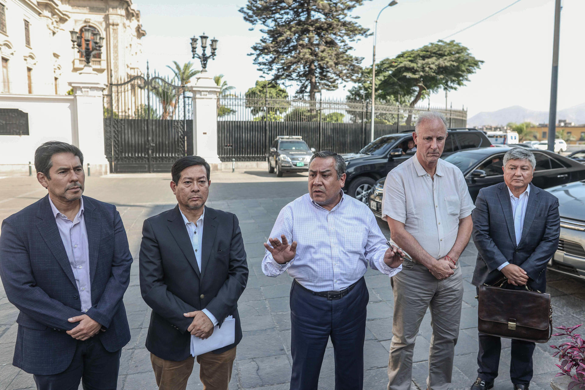 El presidente del Consejo de Ministros de Perú, Gustavo Adrianzén (c), da declaraciones a periodistas acompañado por otros ministros este sábado, afuera del Palacio de Gobierno de Perú en Lima (Perú). EFE/ Stringer